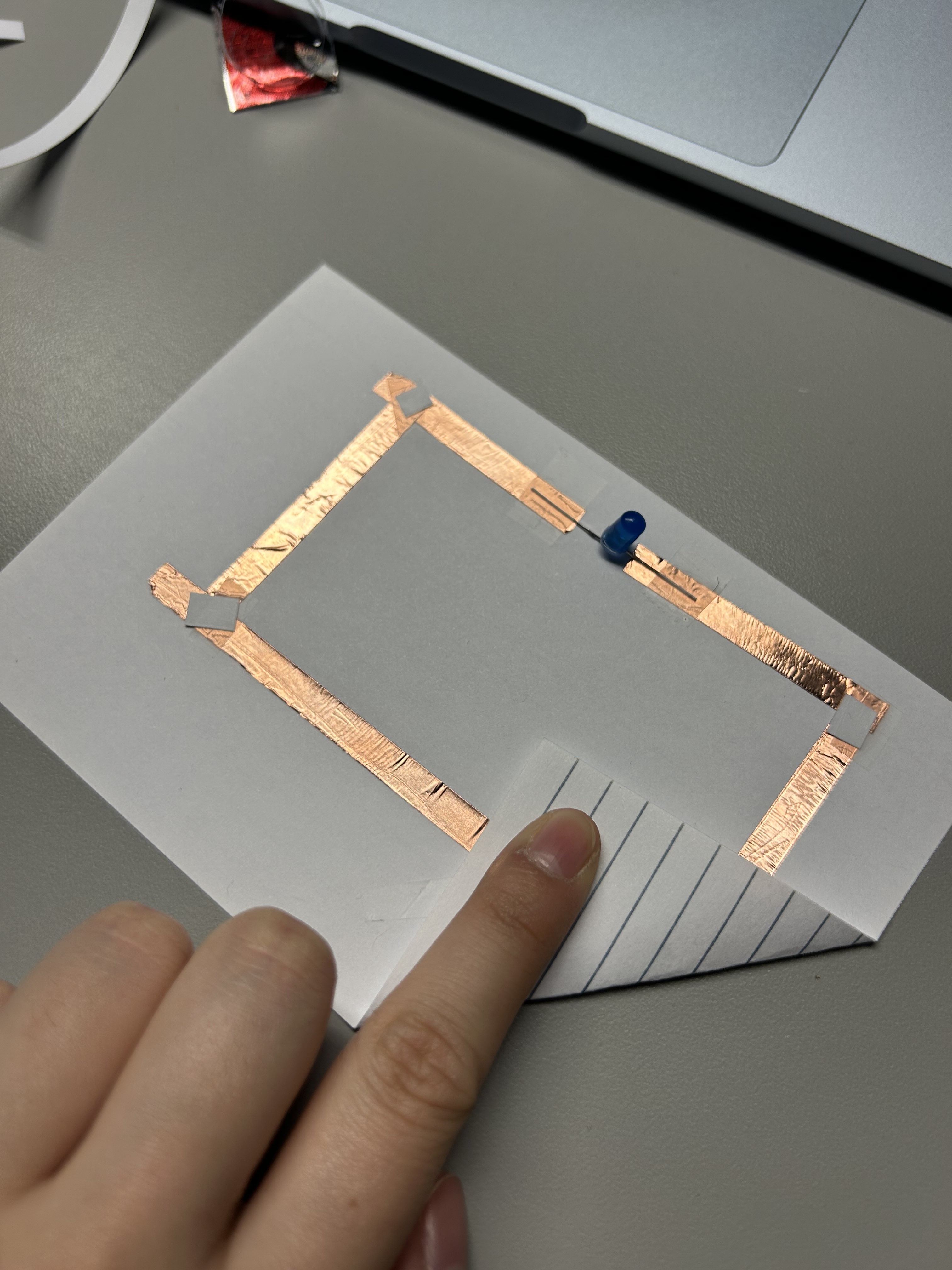 I got some feedback from my peers, and realized the conductive tape wasn't connected properly, because the sticky side was not conductive, so I taped on bits of the conductive tape, and taped it on the edges where it didn't connect to connect them, but that didn't solve the issue either.