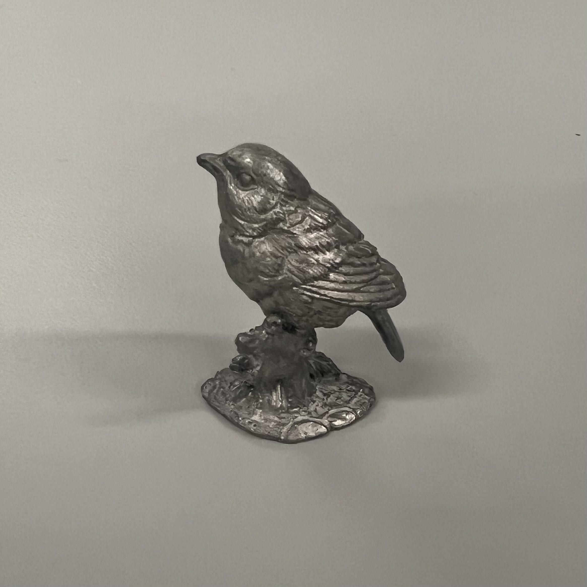 This object is made out of metal, and has a dark grey colour. It's rigid, reflective, and cool to the touch. The object is refined, and can be used for sculptures, jewelry, and tools.